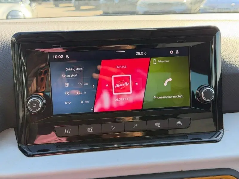 Écran tactile central de la SEAT Arona 2025 affichant radio FM/DAB et téléphone non connecté, vue frontale rapprochée.