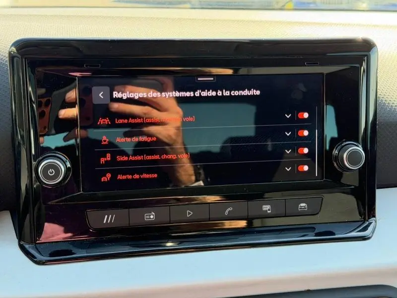 Écran tactile central du SEAT Arona 2025 affichant les réglages des aides à la conduite, avec commandes physiques autour.