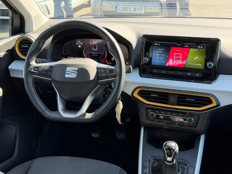 Vue intérieure frontale du tableau de bord de la SEAT Arona gris Magnétique avec volant cuir multifonction et écran tactile central.