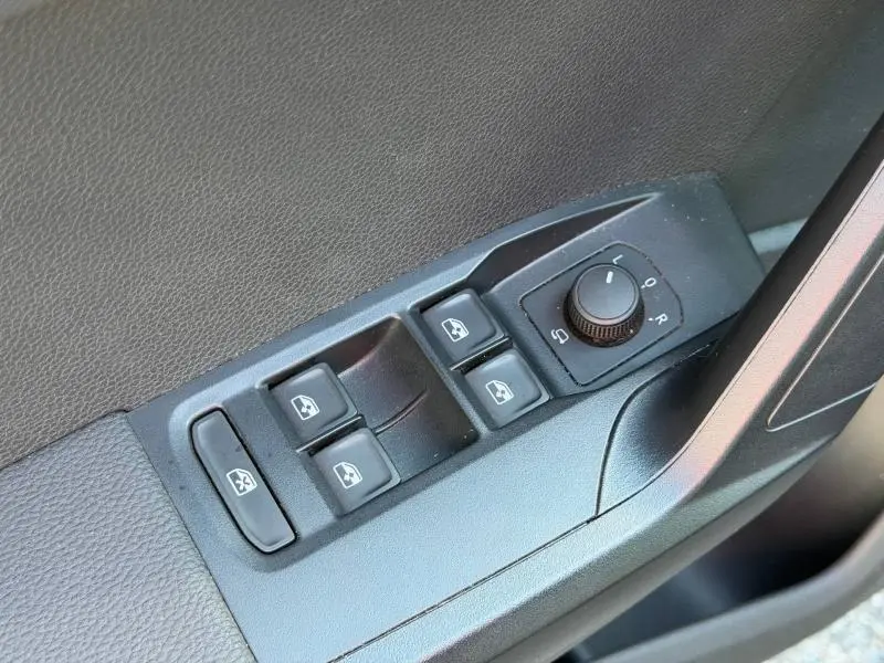 Gros plan sur les commandes des vitres électriques et rétroviseurs côté conducteur du SEAT Arona gris Magnétique Métal.