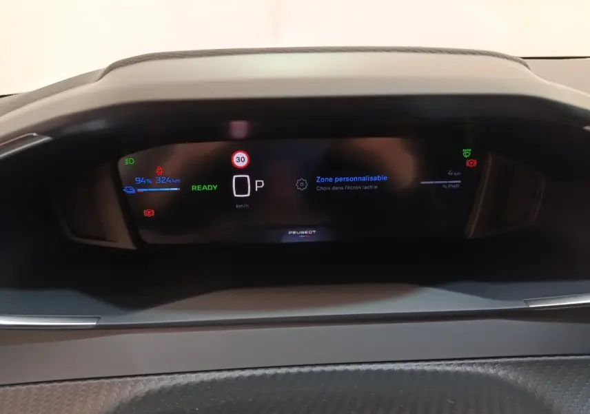 Tableau de bord numérique du Peugeot 208 électrique 2024, affichage multifonctions avec indication batterie et vitesse.