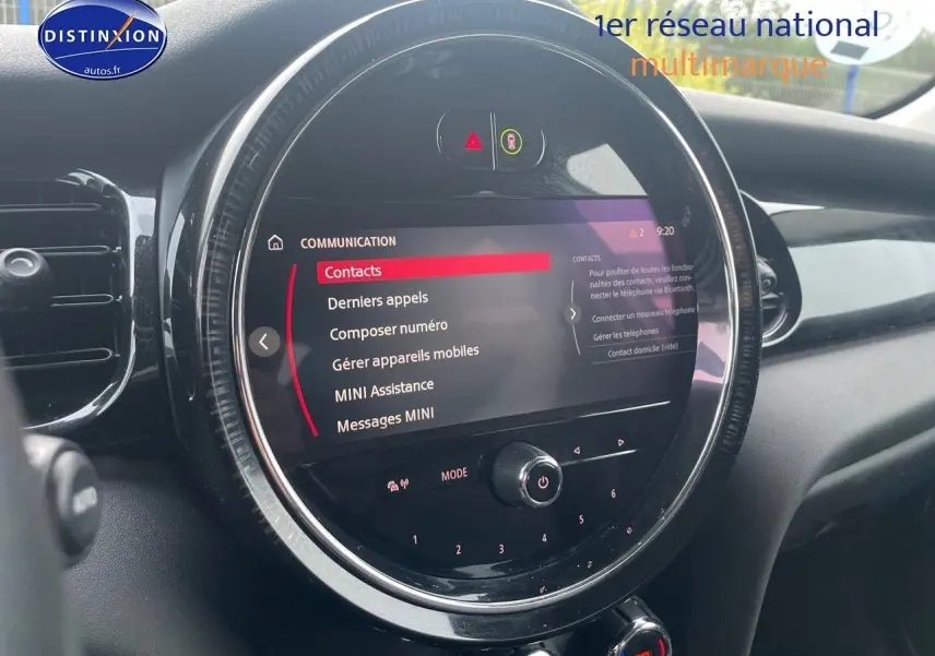 Vue rapprochée de l'écran central tactile circulaire du tableau de bord d'une MINI blanche nacrée 2023.