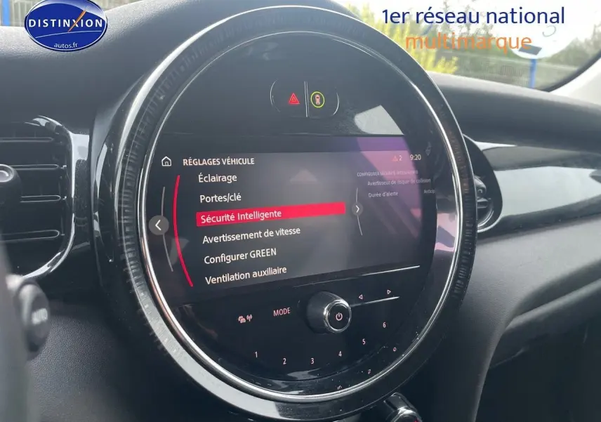 Écran central rond affichant les réglages de sécurité dans l'habitacle d'une MINI blanche nacrée 2023.