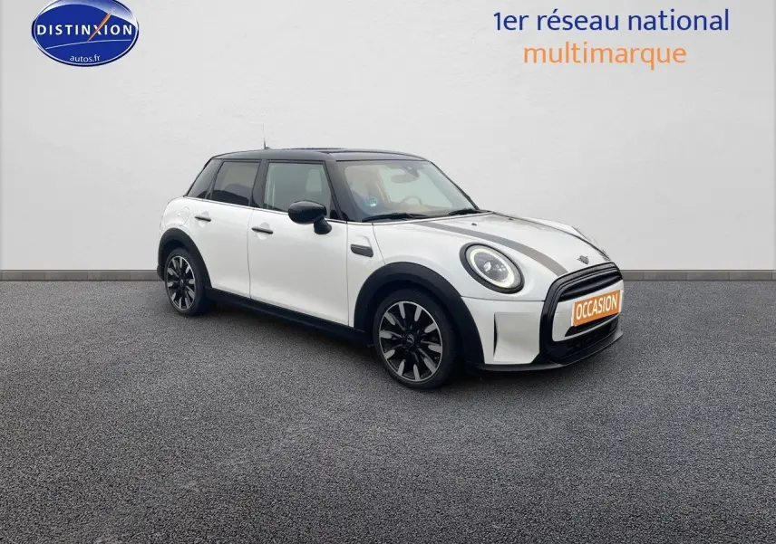 Vue 3/4 avant droit d'une MINI 1.5 136CH blanche nacrée avec toit noir et jantes bi-ton sur sol gris.