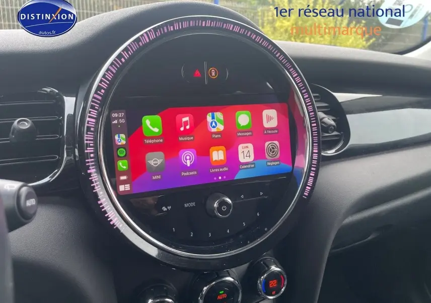 Tableau de bord de MINI 2023 avec écran tactile circulaire affichant applications, entouré d'un anneau lumineux violet.