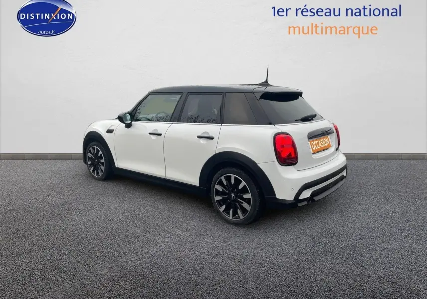 Vue 3/4 arrière droite d'une MINI 1.5 136CH blanche nacrée avec toit noir et jantes bi-ton.