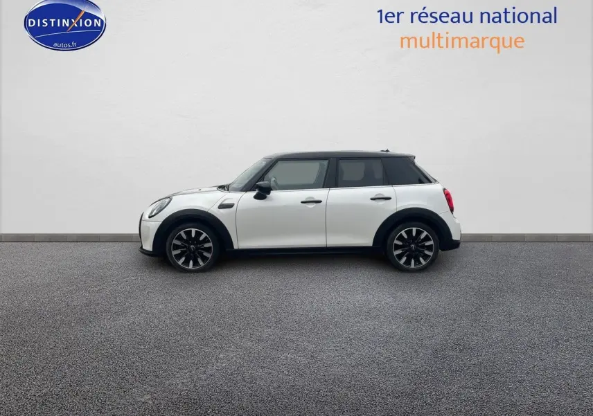 Profil droit d'une MINI 1.5 136CH STEPTRONIC blanc nacré avec toit noir et jantes bi-ton sur fond neutre.