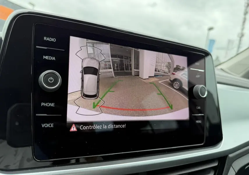 Écran de caméra de recul du Volkswagen T-Roc blanc pur montrant l’arrière et les lignes de guidage vertes et rouges.