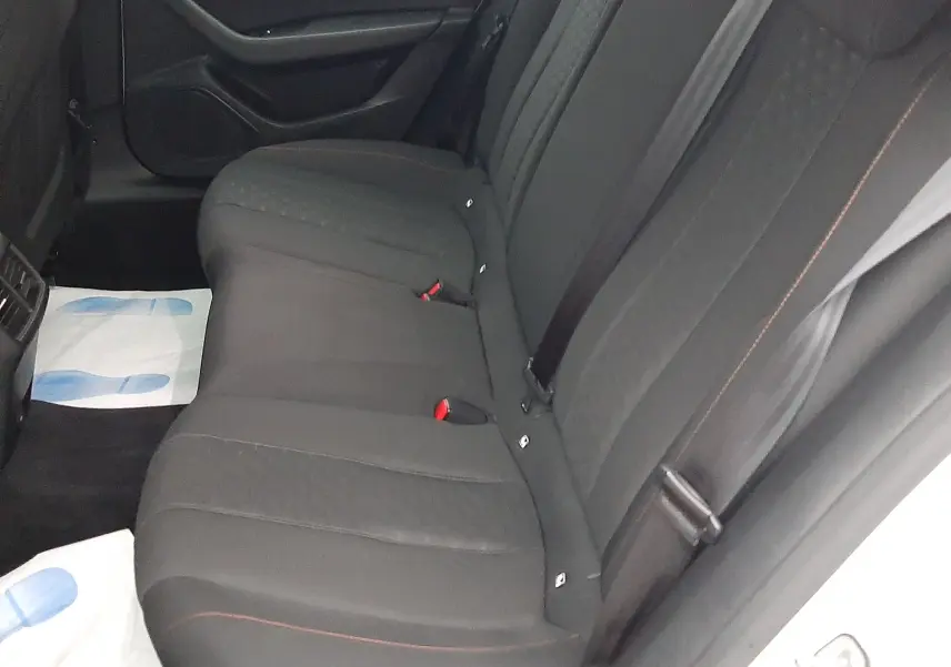 Vue intérieure côté droit des sièges arrière noirs de la Peugeot 508 blanche, avec ceintures et habillage de porte visible.