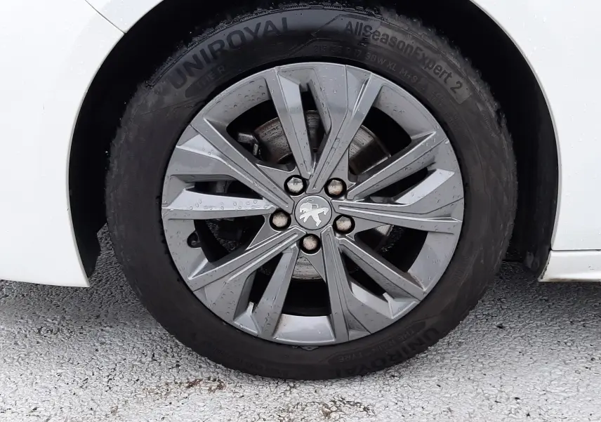 Gros plan sur la roue avant gauche blanche d'une Peugeot 508 1.5 BlueHDi 130 Active avec jante alliage grise.