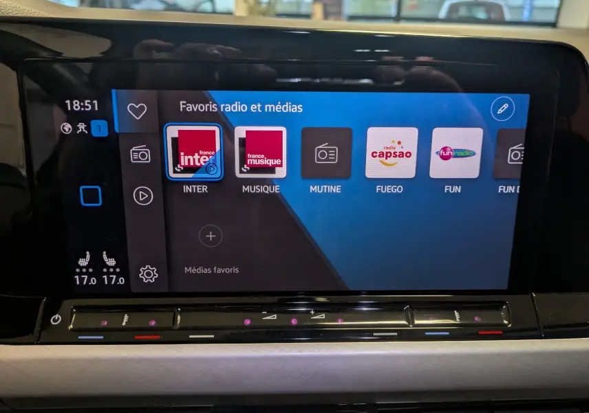 Écran tactile central du tableau de bord de la Volkswagen Golf 2024 affichant les favoris radio et médias.