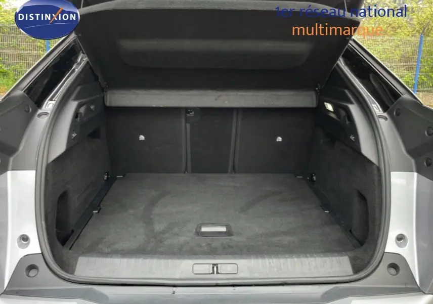 Coffre ouvert vu de l'arrière d'un Peugeot 3008 gris Artense Métal, montrant un espace de chargement propre et spacieux.