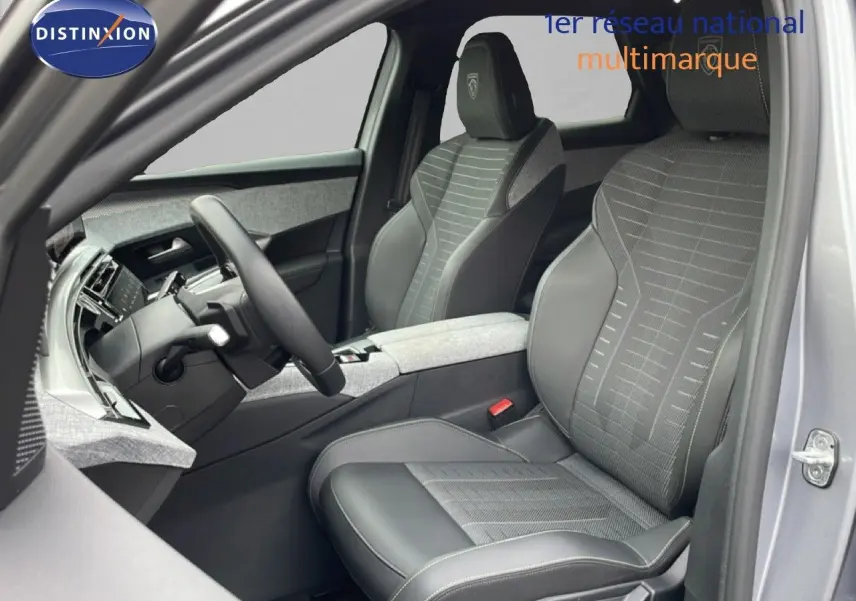 Vue intérieure côté conducteur du Peugeot 3008 gris Artense, mettant en valeur les sièges cuir et tissu avec logo GT brodé.