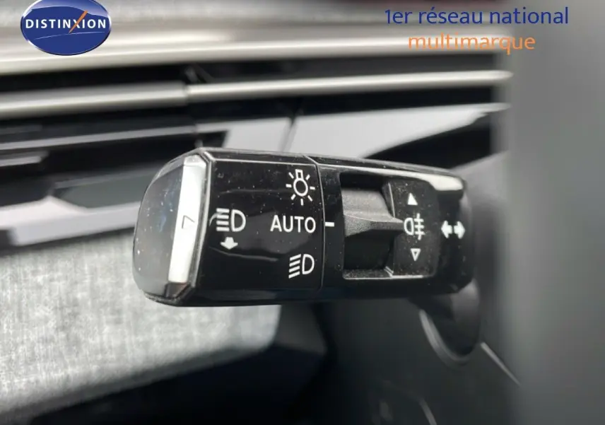 Gros plan sur la commande des phares du Peugeot 3008 gris Artense, montrant les réglages automatiques et feux antibrouillard.