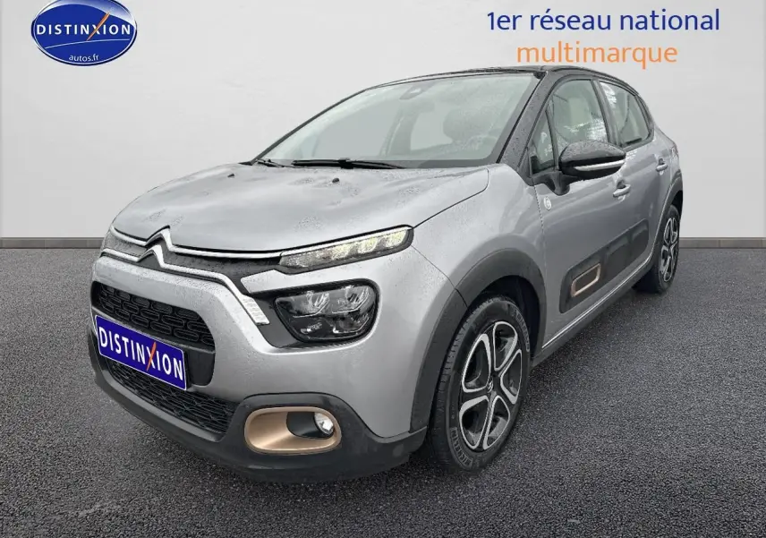 Citroën C3 gris acier vue 3/4 avant droit avec enjoliveurs noirs et détails couleur bronze sur pare-chocs et portières.