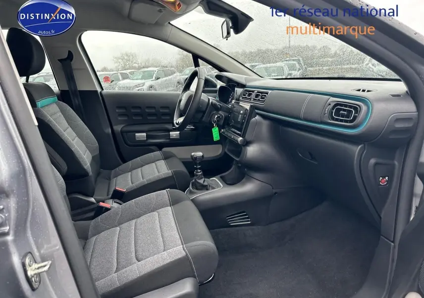 Vue intérieure côté conducteur de la Citroën C3 1.2 PureTech 110 gris acier, avec sièges tissu mica grey et tableau de bord moderne.