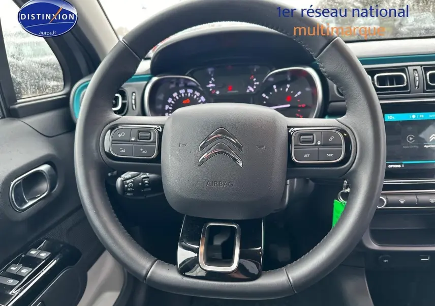 Vue intérieure centrée sur le volant noir d’une Citroën C3 2023 avec tableau de bord et écran tactile visible.