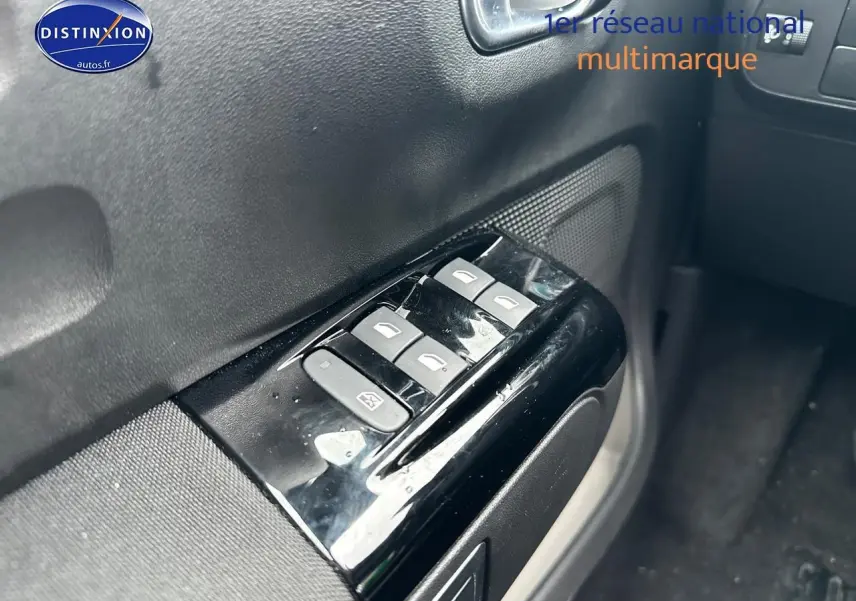Gros plan sur les commandes de vitres électriques côté conducteur de la Citroën C3 gris acier 2023.