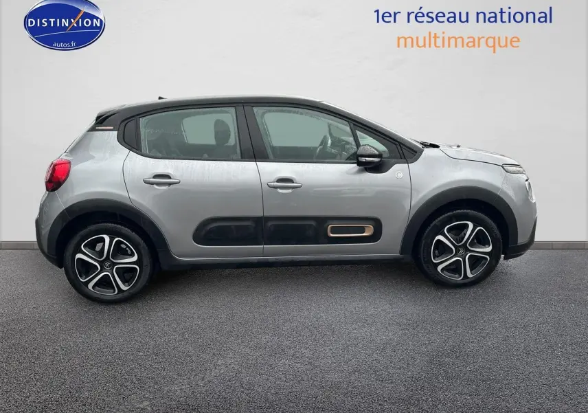 Profil côté gauche d'une Citroën C3 gris acier 2023 avec protections noires et jantes alliage distinctives.