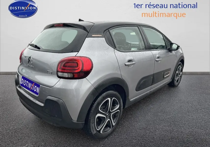Vue 3/4 arrière droite d'une Citroën C3 gris acier avec toit noir et protections latérales noires.