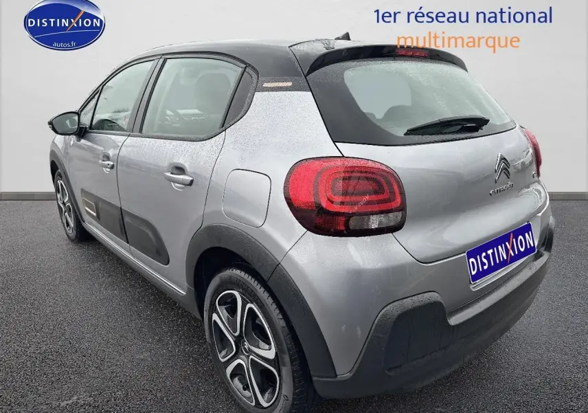 Vue 3/4 arrière droite d'une Citroën C3 gris acier avec feux arrière arrondis et protections noires sur les bas de caisse.