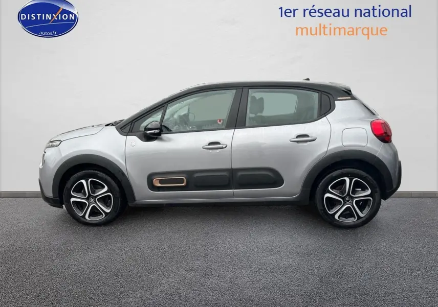Profil droit d'une Citroën C3 gris acier 2023 avec protections latérales noires et jantes alliage bicolores.