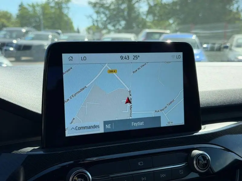 Écran tactile central du Ford Kuga 2023 affichant la navigation GPS, avec tableau de bord noir en arrière-plan.