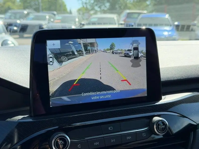 Écran tactile intérieur montrant la caméra de recul du Ford Kuga gris Solar, vue arrière avec guidage de trajectoire coloré.
