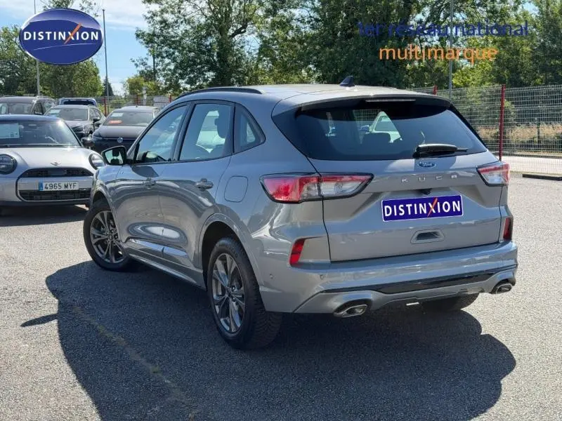 Vue 3/4 arrière droite du Ford Kuga gris Solar métallisé 2023 avec double sortie d’échappement et jantes alu.