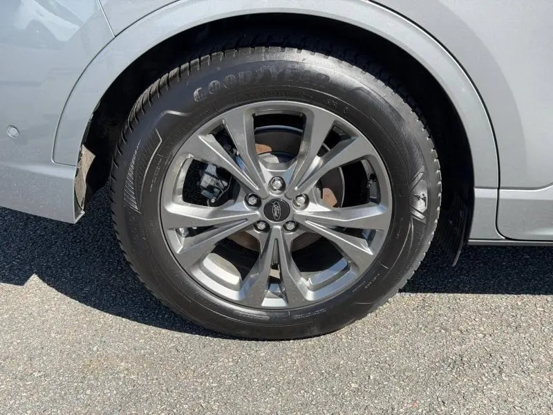 Gros plan sur la roue avant droite d’un Ford Kuga gris Solar Métallisée avec jante alliage et pneu Goodyear.