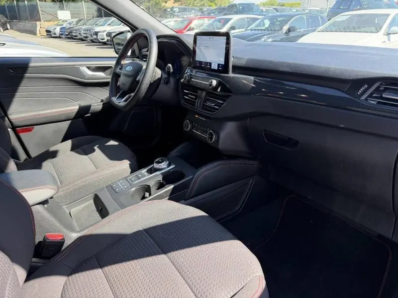 Vue intérieure côté conducteur du Ford Kuga 1.5 EcoBlue 2023 avec tableau de bord noir et écran tactile central.