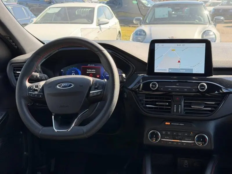 Vue intérieure frontale du tableau de bord et volant cuir multifonction du Ford Kuga gris Solar 2023 avec écran tactile GPS.