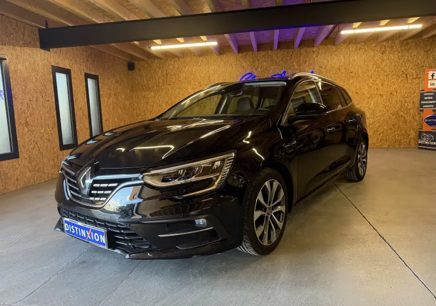 Renault Mégane Estate noir étoilé vue 3/4 avant droit dans un garage avec éclairage intérieur.