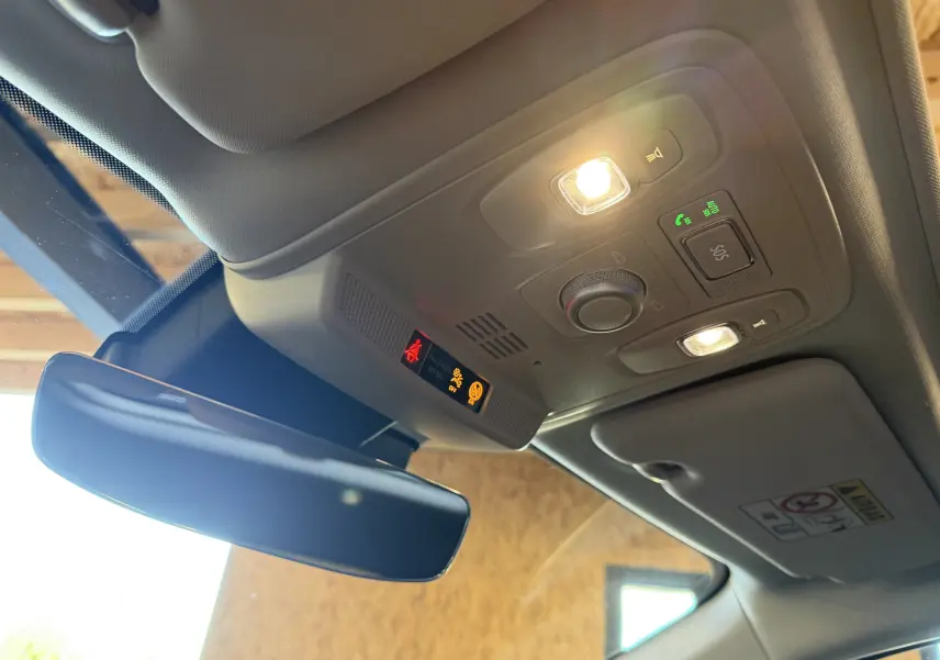 Vue intérieure du plafond avant de la Renault Mégane Estate 2024, avec plafonnier allumé et rétroviseur central.