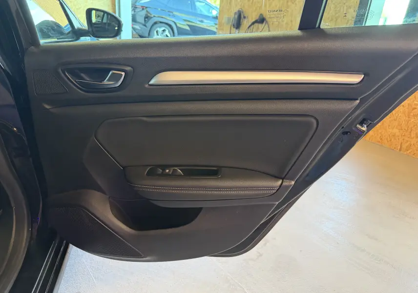 Vue intérieure de la porte arrière gauche noire de la Renault Mégane Estate 2024 avec garniture en cuir et insert métallique.