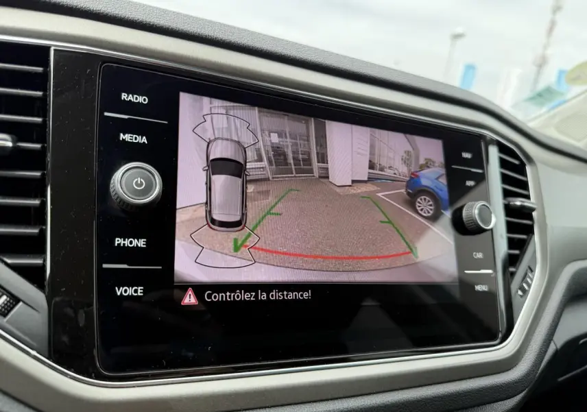 Écran multimédia du Volkswagen T-Roc 2021 montrant la caméra de recul avec vue arrière et alertes de distance.