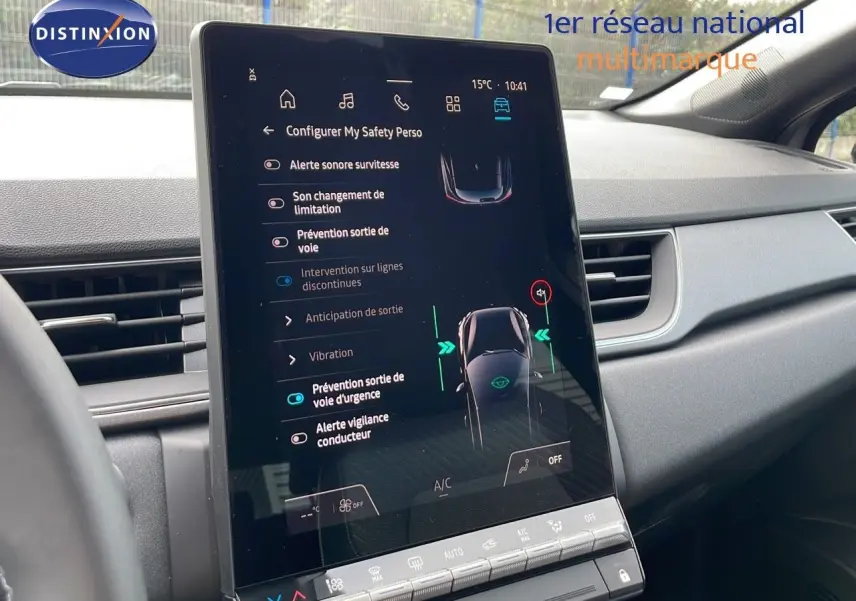 Vue intérieure centrée sur l'écran tactile du tableau de bord du Renault Captur gris Cassiopée 2025, affichant les aides à la conduite.