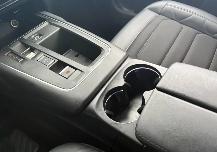 Vue rapprochée de la console centrale noire et des sièges tissu gris du Citroën C5 Aircross Hybrid 2024.