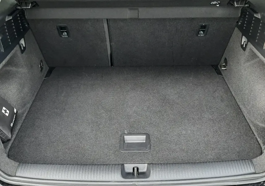 Coffre ouvert vu de l'arrière d'un Audi Q2 noir mito metal, espace de chargement propre et vide.