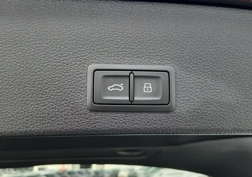 Gros plan sur les boutons d'ouverture et de verrouillage du hayon intérieur d'un Audi Q2 noir mito metal 2023.