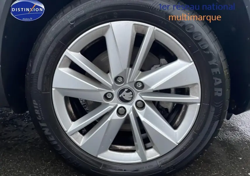 Gros plan sur la jante alu argentée d'une Skoda Karoq blanche glacial, vue côté droit, pneu Goodyear visible.