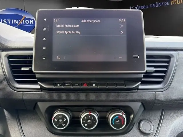 Écran tactile central du tableau de bord du Renault Trafic Fourgon gris clair, avec commandes climatisation et boutons fonctionnels visibles.