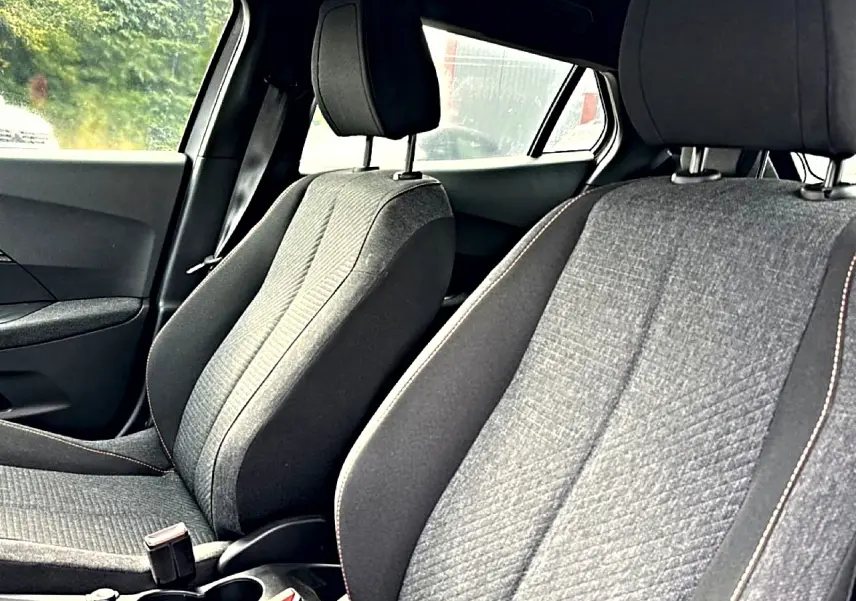 Vue intérieure des sièges avant gris du Peugeot 2008 1.2 hybrid 145 style e-dcs6, côté conducteur et passager.