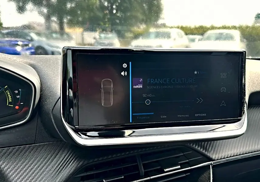Vue intérieure centrée sur l'écran tactile multifonction du tableau de bord du Peugeot 2008 gris 2025.
