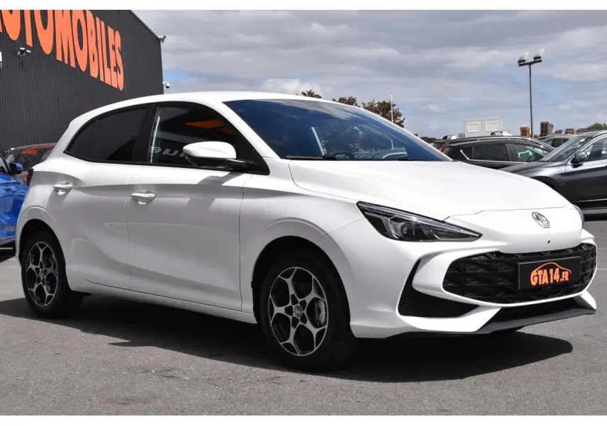 MG3 blanc en vue 3/4 avant droit, avec jantes alliage distinctives et calandre noire sportive.