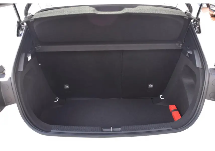 Coffre ouvert vu de l'arrière d'une MG3 blanche, montrant un espace de chargement vide avec un triangle de sécurité rouge.