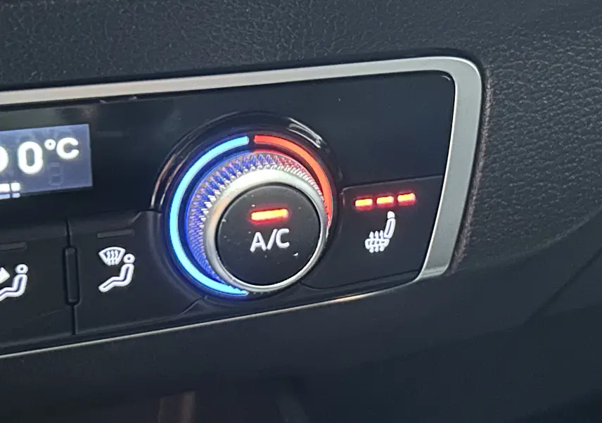 Gros plan sur la console centrale noire de l'Audi Q2 35 TFSI avec prise USB et allume-cigare 12V visibles.