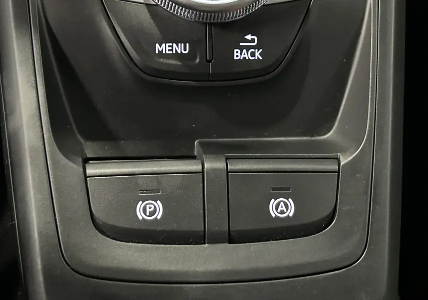 Gros plan sur les commandes audio et navigation au volant d'un Audi Q2 noir métal 2023 finition S-Line.