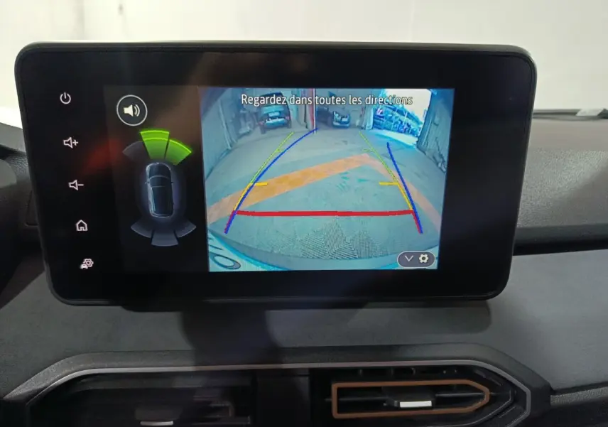 Écran tactile central affichant la caméra de recul et l’aide au stationnement sur un tableau de bord Dacia Sandero bleu.