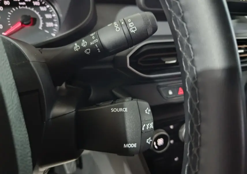 Détail intérieur du volant et commandes au volant de la Dacia Sandero Extreme+ TCe 110 2024, vue rapprochée côté gauche.